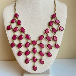 Bib style statement necklace with faceted maroon wine ovals in goldtone setting